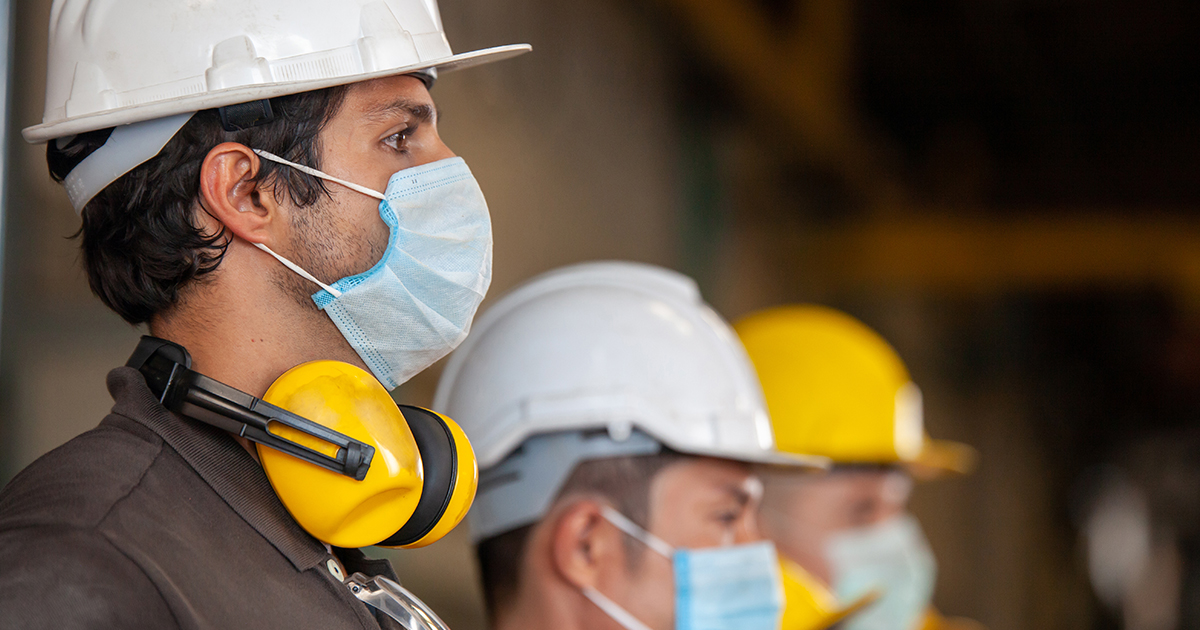 Workers wear protective face masks