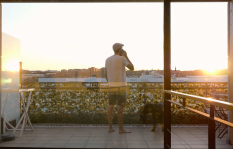 man standing balcony sunset