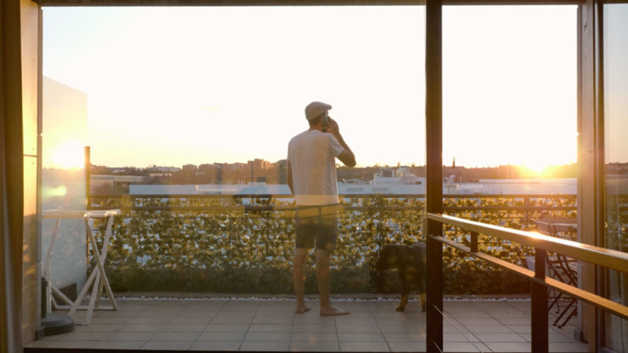 man standing balcony sunset