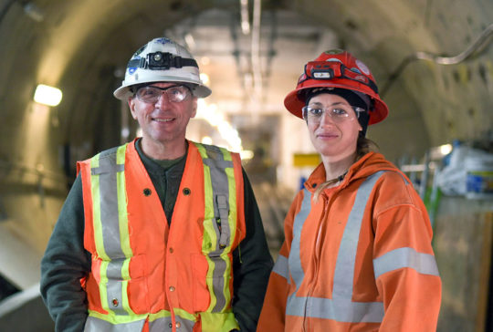 man and woman wearing safety vests and protective gear