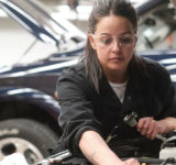 Female mechanic working on car