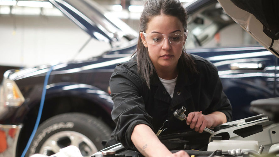 Female mechanic working on car