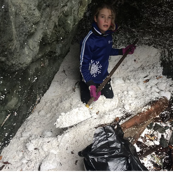 young girl shovelling plastic pollution