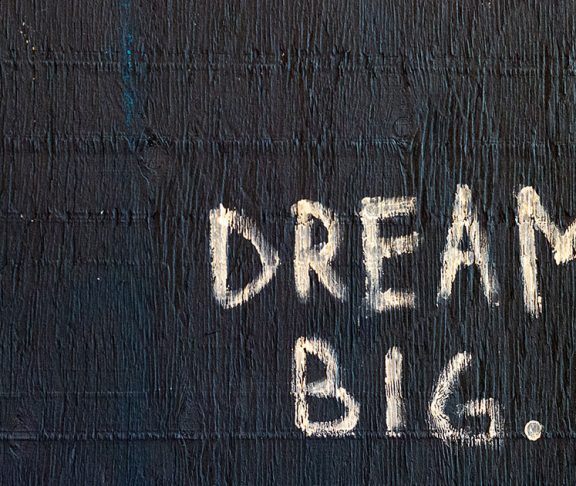 Betonvæg med 'Dream Big' påmalet i hvidt