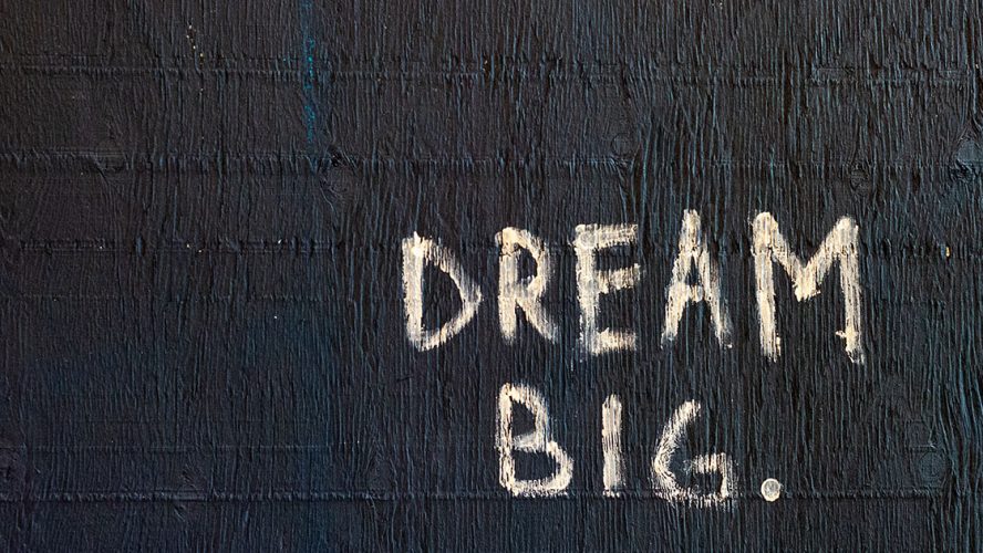 Betonvæg med 'Dream Big' påmalet i hvidt