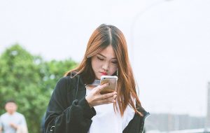 Kinesisk kvinde kigger på sin smartphone