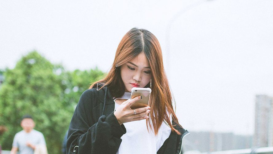 Kinesisk kvinde kigger på sin smartphone