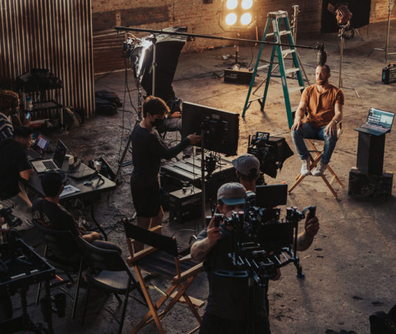 A film set and crew preparing for a shoot in a warehouse