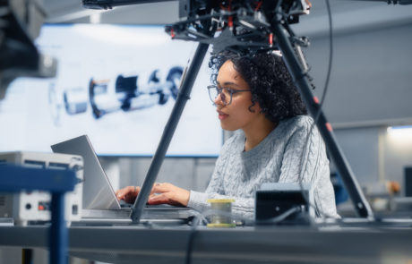 Concentrated Black Female Engineer Writing Code. Developing Software for Drone Control in the Research Center Laboratory. Technological Breakthrough in Flight Industries Concept.