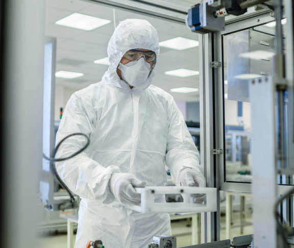 In the Manufacturing Facility Scientist Wearing Sterile Protective Coverall