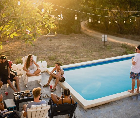 Selskab hygger i sommerhus med pool