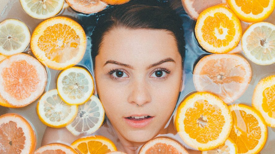 Kvinde bader med skivede citrusfrugter