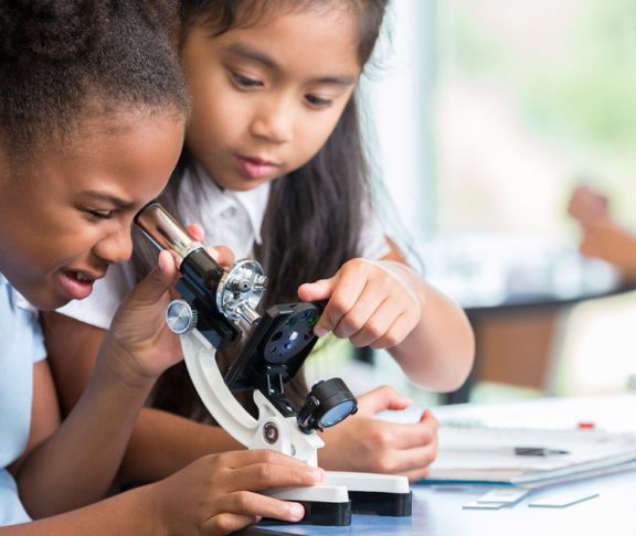 Two younng girls using a microscope