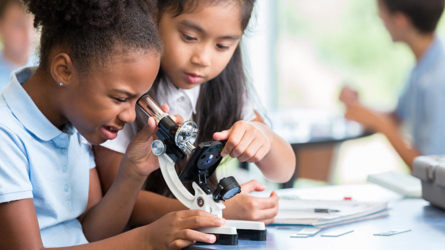 Two younng girls using a microscope