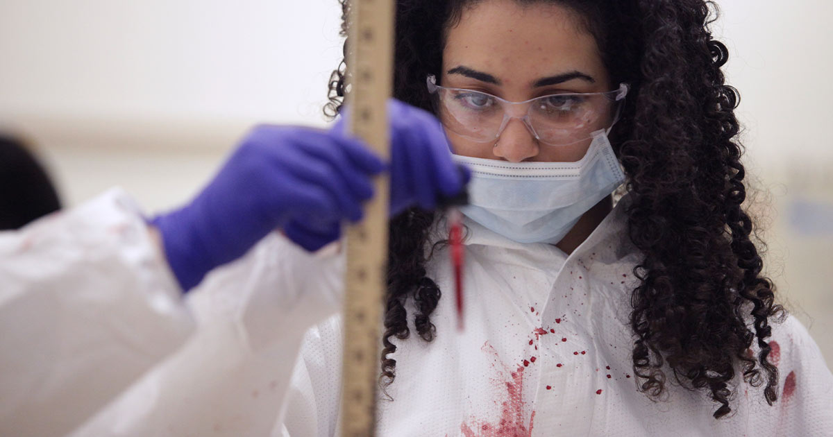 Female student learning about blood spatter patterns