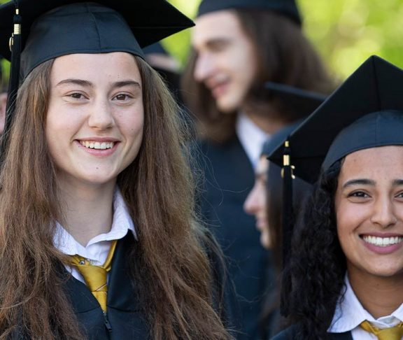 Two girls smiling at high school convocation