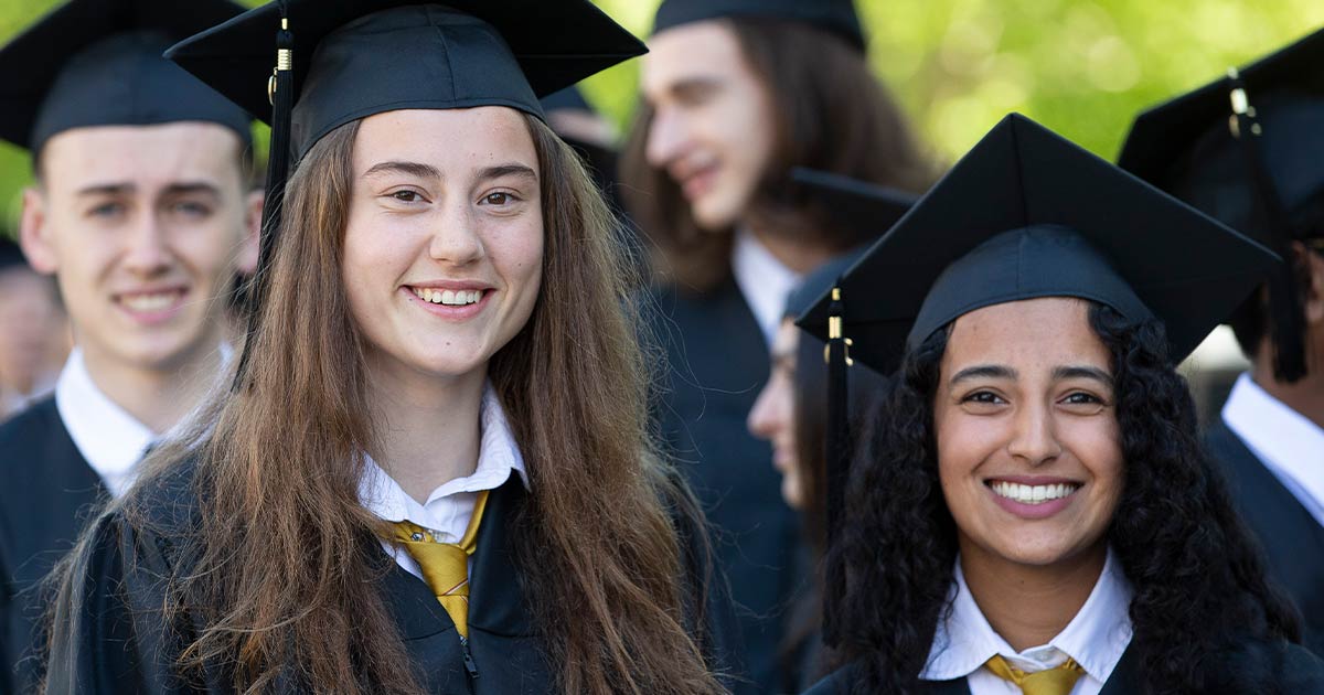 Two girls smiling at high school convocation
