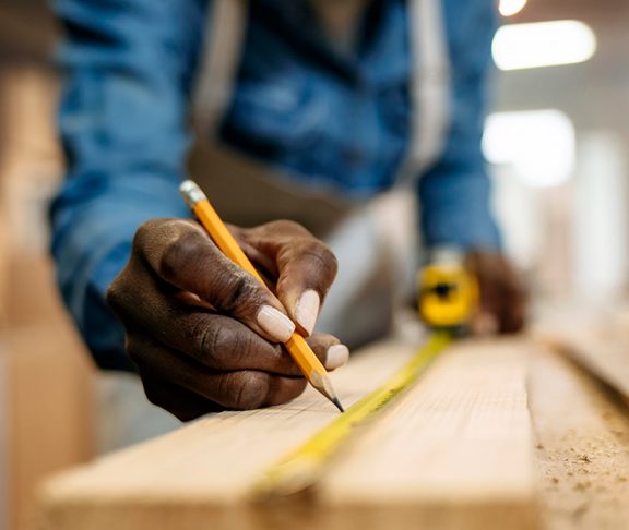 Carpenter marking measurements on wood