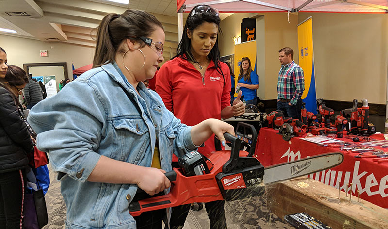 Raquel McLaren supervises a student using a chainsaw