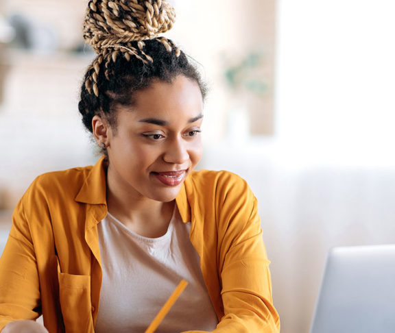 black woman smiling at computer screen