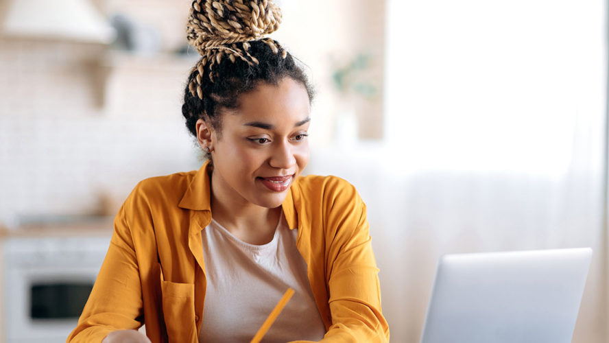 black woman smiling at computer screen