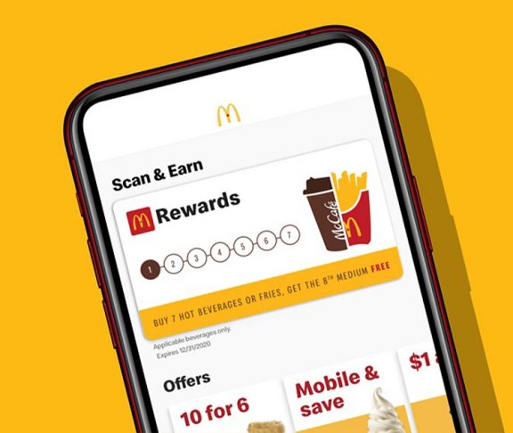 McDonald's app on a phone against a golden background
