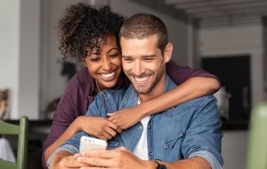 Couple happily browsing a smartphone together