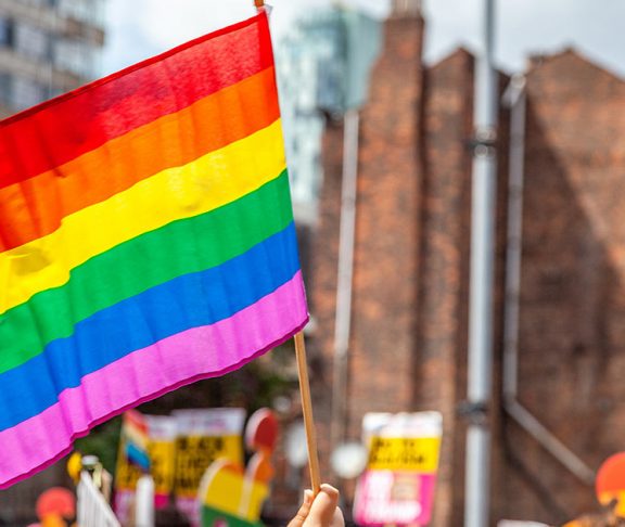 Waving a rainbow flag at a Pride Parade