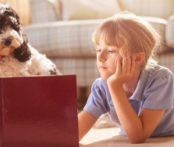 Young girl and her dog reading a book