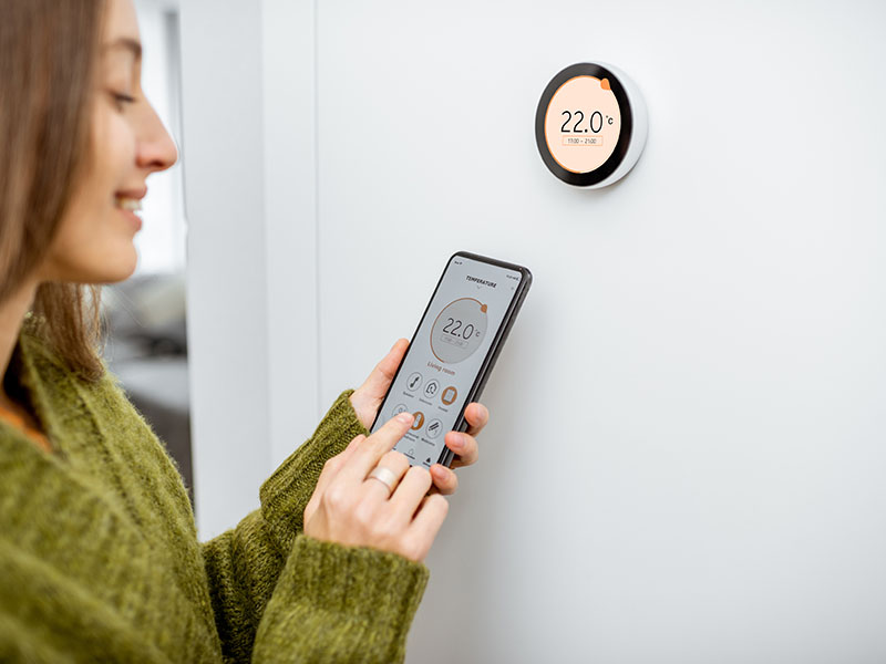 Woman-setting-her-thermostat-green-energy