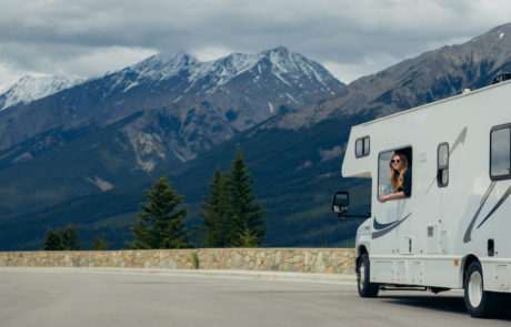 Woman leaning out of RV with mountains in the background