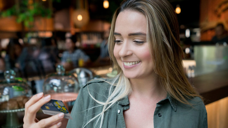 young woman smiling at rewards card