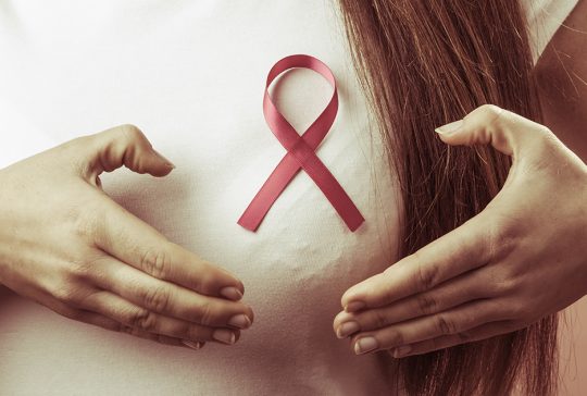 kobieta ze wstążką symbolizującą walkę z rakiem piersi