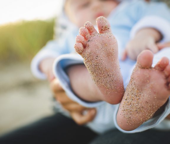stopy dziecka ubrudzone piaskiem