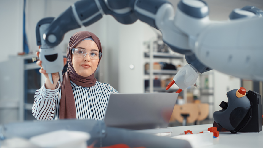 Portrait of Muslim Businesswoman Wearing Hijab and Working on Engineering Project, Coding on Laptop and Changing Robot Hand Position.