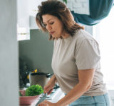 En kvinne som skjærer paprika på kjøkkenet