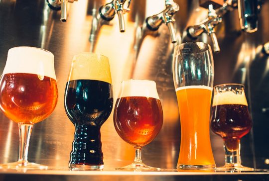 forskellige øl typer står sat op på en bar