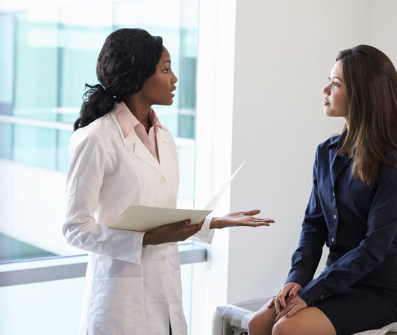 Female Doctor Meeting With Patient In Exam Room