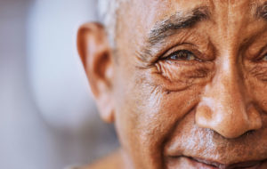 Portrait of a happy, kind black senior mans face with wrinkles, smile and friendly in a retirement home.