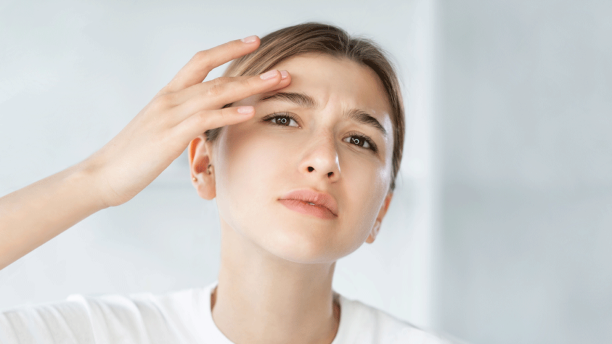 Sensitive skin acne problem woman touching face