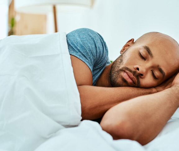 Cropped shot of a young man sleeping in his bed