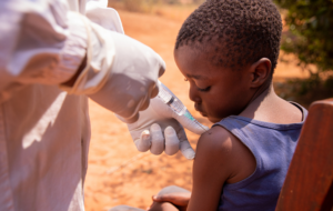 Close-up of a doctor injecting the vaccine to a child in africa.