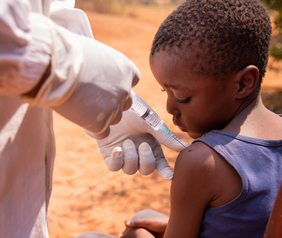 Close-up of a doctor injecting the vaccine to a child in africa.