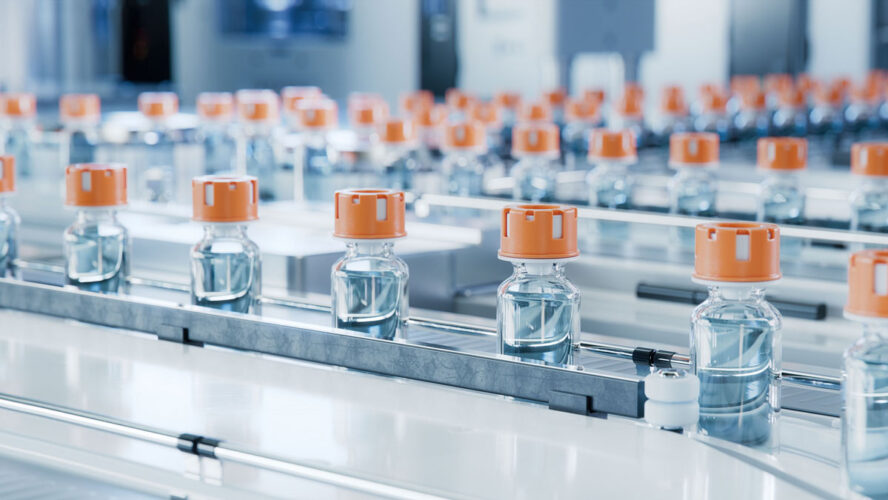 Glass Vials with Orange Caps on Conveyor Belt at Vaccine Production Facility. Medication Manufacturing Process. Medical Ampoule Production Line at Modern Pharmaceutical Factory