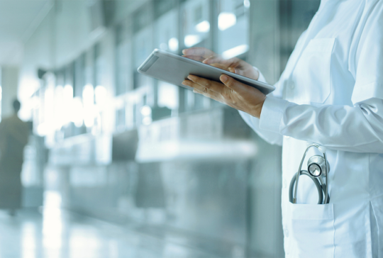 Doctor working on digital tablet on hospital background