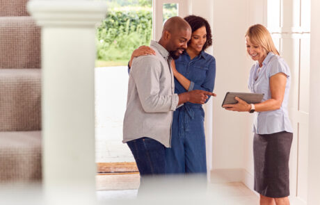 Couple Viewing Potential New Home With Female Real Estate Agent - stock photo