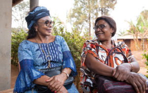 Two senior African ladies friends are sitting and chatting, African women traditionally dressed together, adult friendship concept