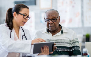 aging-african-american-man-with-doctor-on-tablet