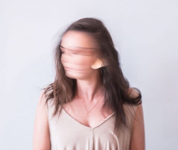 Sløret fotografi af ung kvinde, der ryster på hovedet