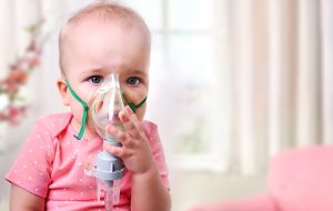 Et barn sidder med ilt maske på fordi hun har astma eller allergi